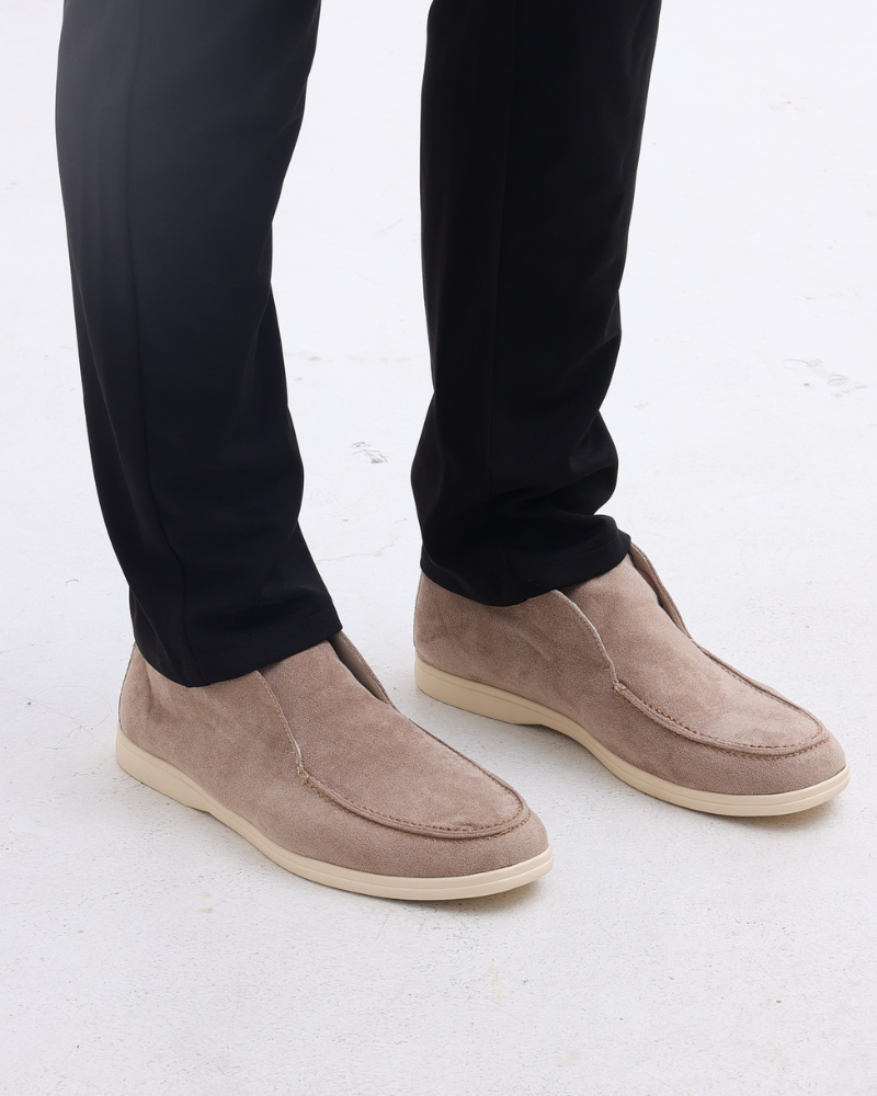 Beige Wildleder-Slipper für Herren, kombiniert mit schwarzen Hosen. Elegante, bequeme Schuhe für stilvolle Freizeit- und Business-Outfits.