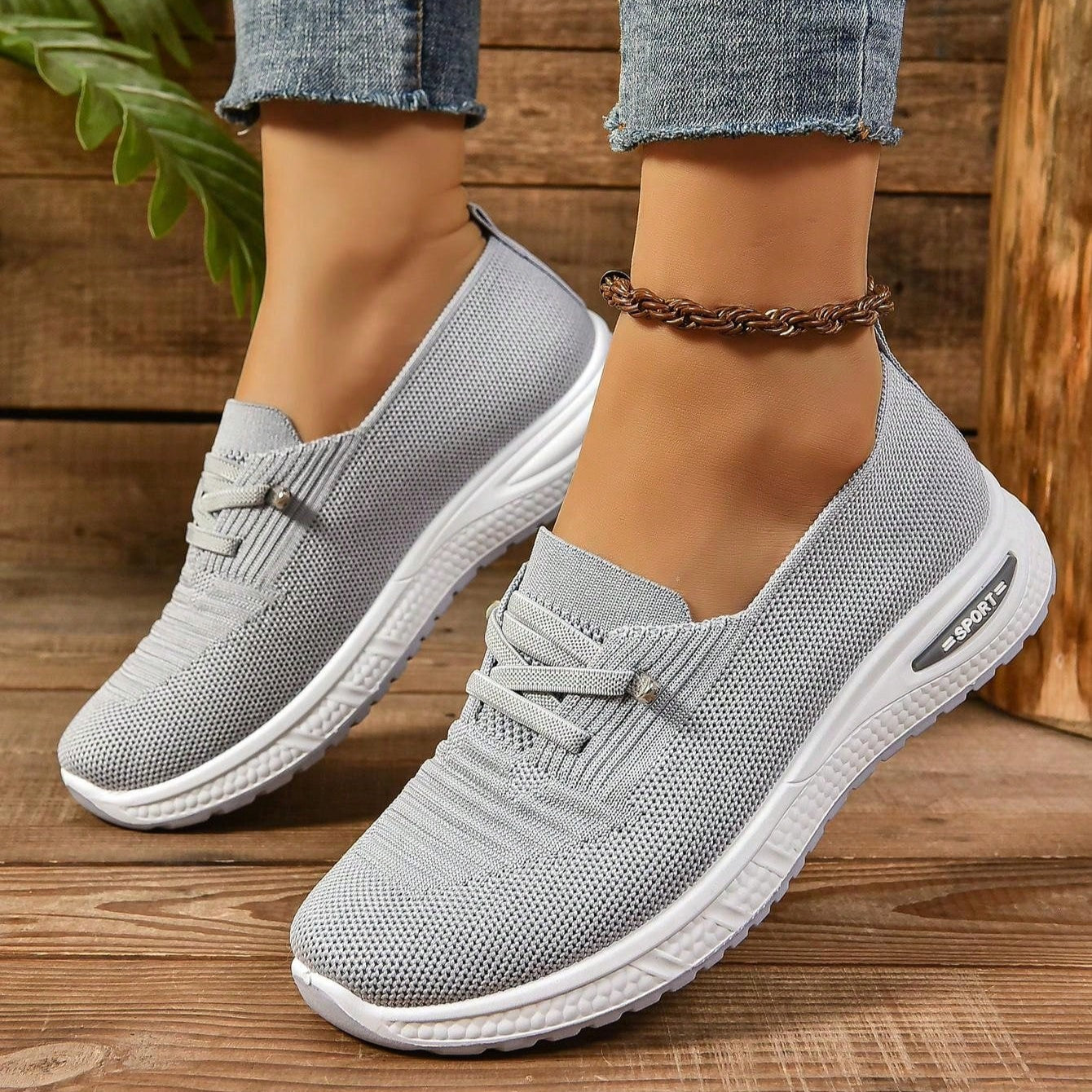 Graue Damen-Sneaker aus Strickmaterial, bequem und atmungsaktiv, mit weißer Sohle. Perfekt für Freizeit und Sport. Trendige, moderne Schuhe.