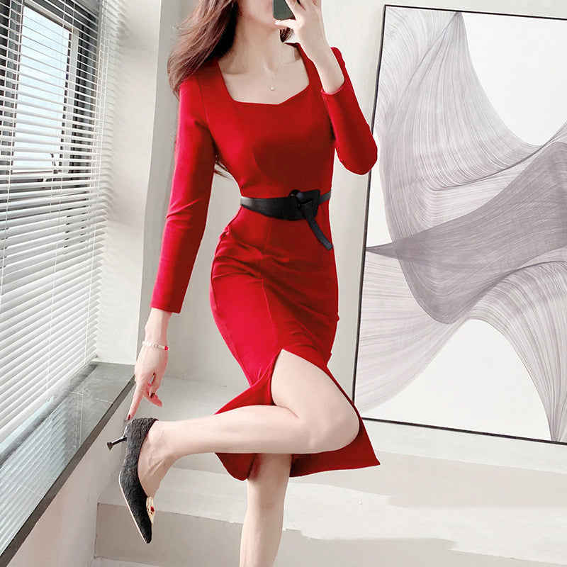 Frau in rotem Kleid mit schwarzem Gürtel posiert elegant in modernem Raum. Stilvolle Mode, rotes Abendkleid, elegantes Design, Damenmode.