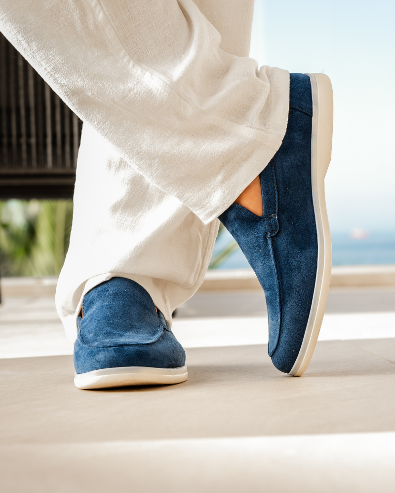 Weiße Leinenhose und blaue Wildleder-Slipper auf Terrasse, stilvolle Sommermode, entspannter Look, Freizeitkleidung, elegantes Schuhwerk.