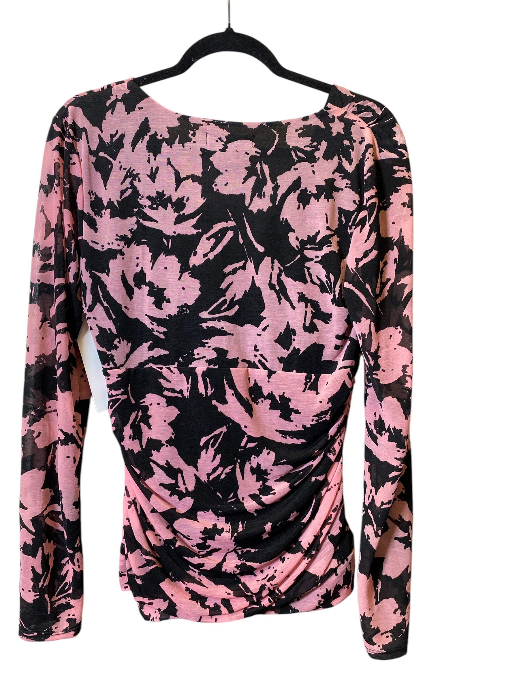Rosa und schwarzes Langarmshirt mit floralem Muster auf Kleiderbügel. Modisches Damenoberteil, ideal für Herbstmode und trendige Outfits.