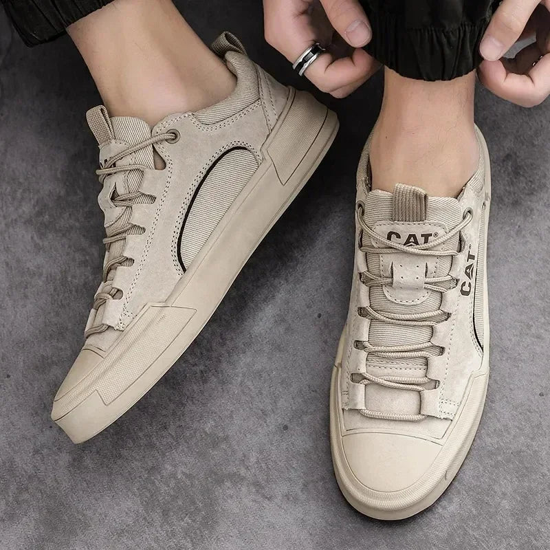 Beige CAT Sneaker aus Leder, seitlich fotografiert auf grauem Hintergrund. Modische Herrenschuhe, ideal für Freizeit und urbanen Stil.