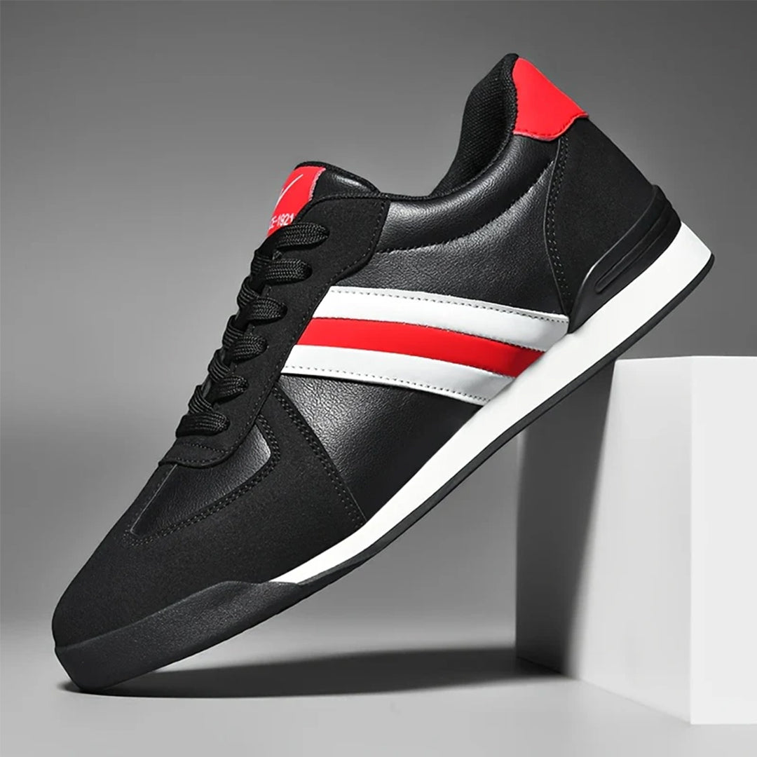 Schwarzer Sneaker mit roten und weißen Streifen, sportliches Design, auf weißem Hintergrund. Modischer Herrenschuh, ideal für Freizeit und Sport.