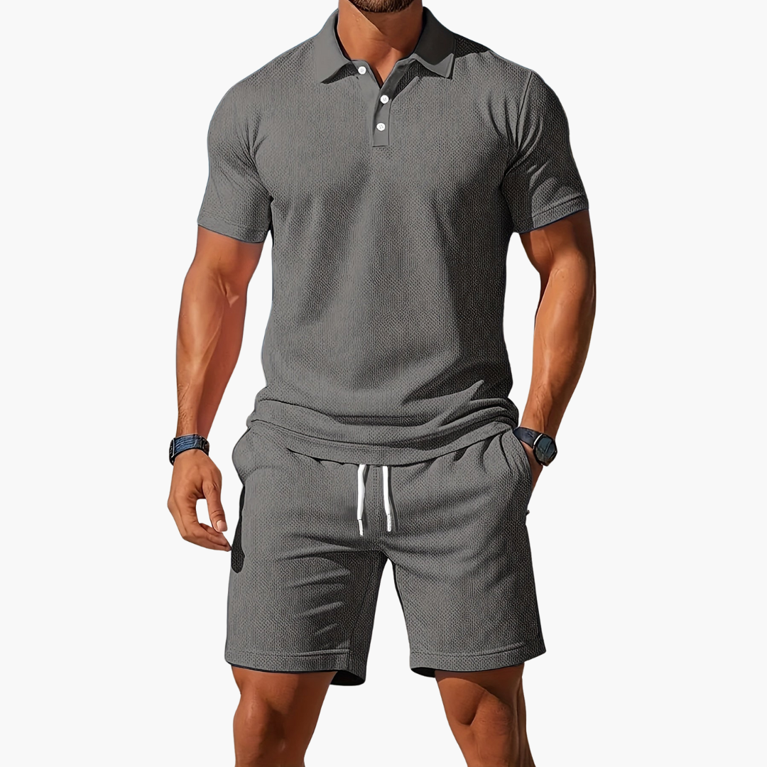 Mann in grauem Poloshirt und Shorts, sportlich-eleganter Look, Sommermode für Herren, Freizeitoutfit, stilvolle Herrenbekleidung.