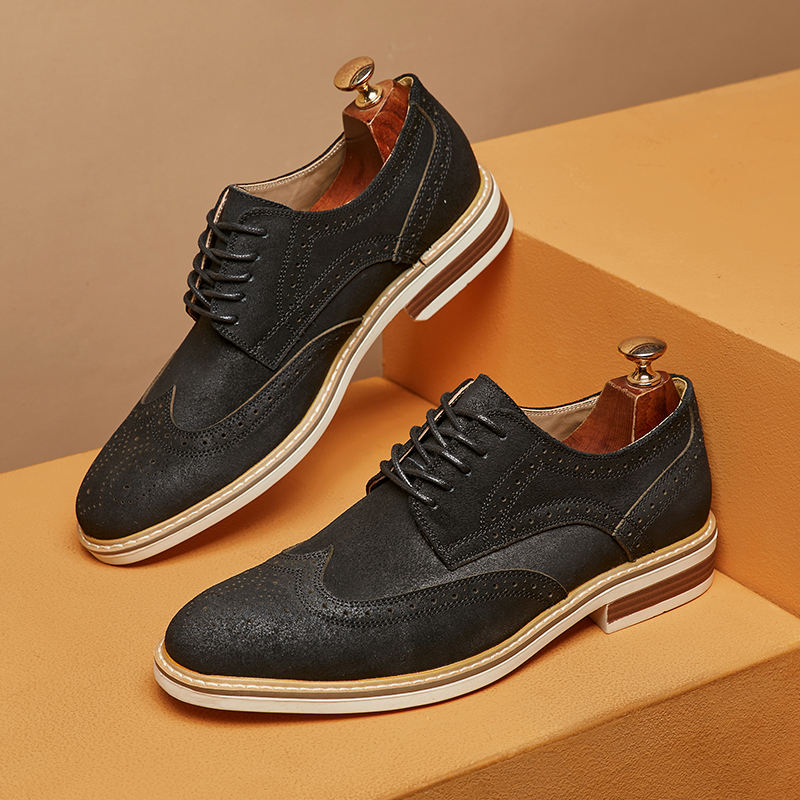 Schwarze Herren-Brogues aus Leder mit weißen Sohlen auf gestuftem, beigem Hintergrund. Elegante Schnürschuhe, ideal für formelle Anlässe.