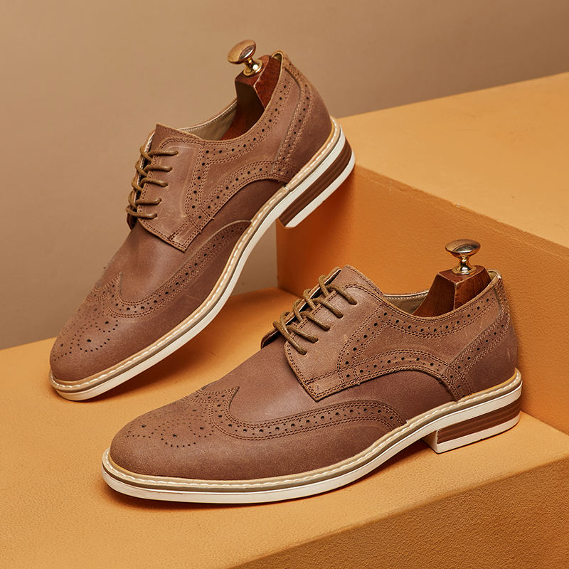 Braune Herren-Brogues aus Leder mit Lochmuster, Schnürung und Holzschuhspanner auf beigem Hintergrund. Elegante Herrenschuhe, klassisches Design.