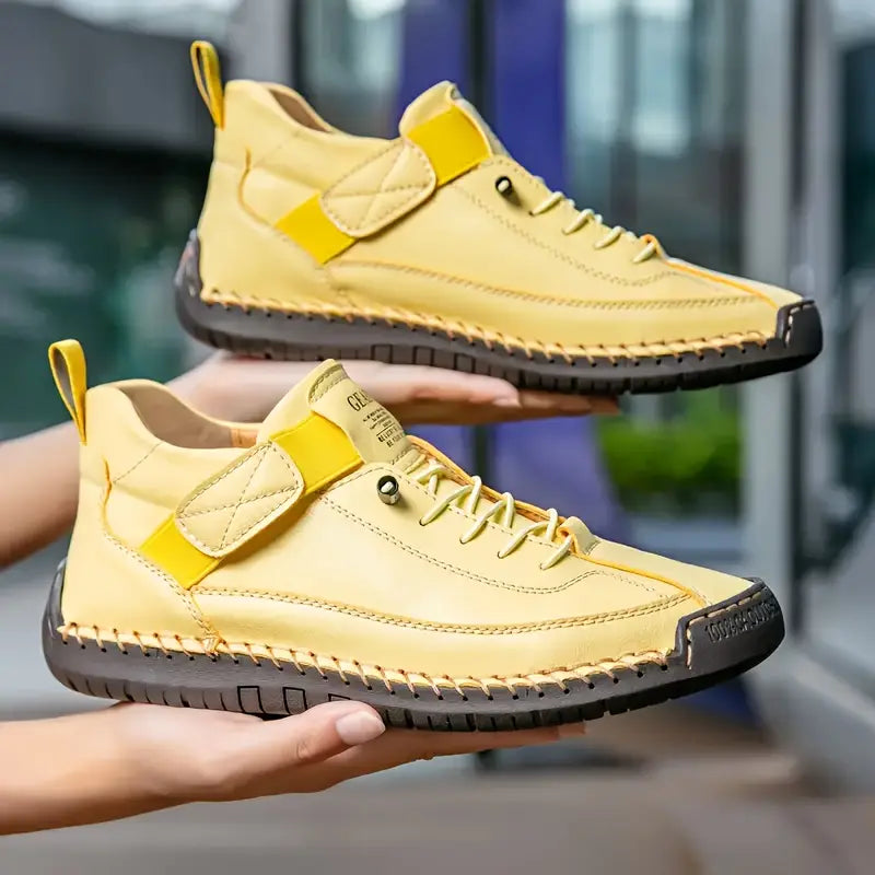 Gelbe Lederschuhe mit schwarzer Sohle, handgehalten, moderne Sneaker-Design, Outdoor-tauglich, stilvoll und bequem, ideal für urbane Abenteuer.