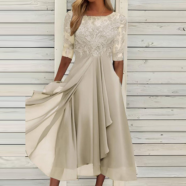 Elegantes cremefarbenes Kleid mit Spitzenoberteil und fließendem Rock, ideal für Hochzeiten oder festliche Anlässe. Damenmode, Abendkleid, elegant.