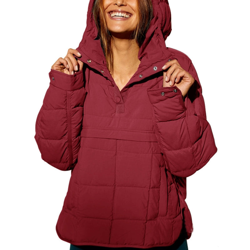 Frau in roter Daunenjacke mit Kapuze, lächelnd. Wintermode, warme Outdoor-Bekleidung, stilvolle Damenjacke für kalte Tage.
