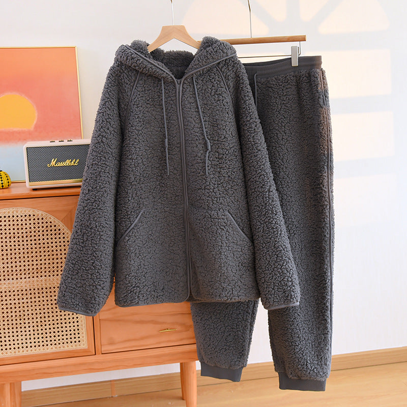 Grauer Fleece-Trainingsanzug mit Kapuze und Reißverschluss, hängend auf Holzkleiderbügel. Bequeme, warme Winterkleidung für Damen.