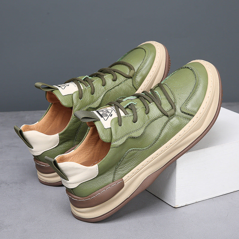 Grüne Ledersneaker mit beiger Sohle, seitlich auf grauem Hintergrund. Modische Herrenschuhe, ideal für Freizeit und Streetwear.