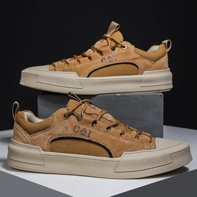 Braune CAT Sneaker auf grauem Podest, seitliche Ansicht. Modische Herrenschuhe, robustes Design, ideal für Freizeit und Outdoor-Aktivitäten.