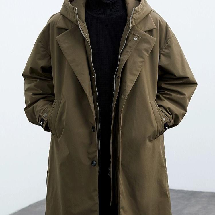 Person in olivgrünem Parka mit Kapuze und schwarzen Pullover. Modischer Mantel, Herbstmode, Outdoor-Bekleidung, stilvoller Look.