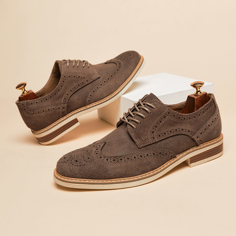 Braune Herren-Brogues aus Wildleder mit Lochmuster, flachem Absatz und Schnürung, auf beigem Hintergrund. Elegante Herrenschuhe, stilvoll und modern.