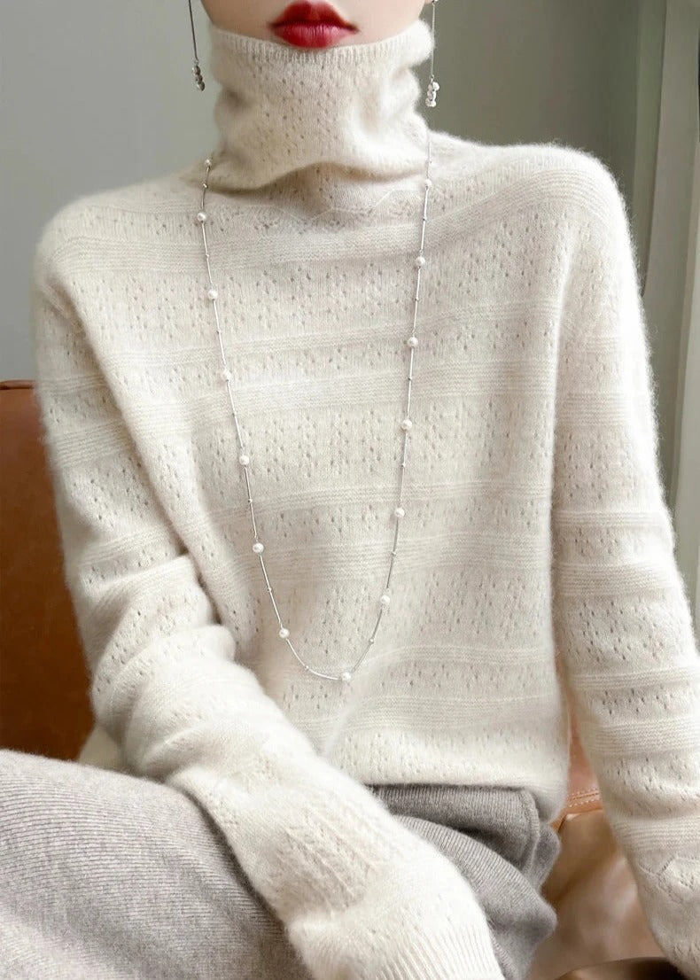 Frau in cremefarbenem Strickpullover mit Rollkragen, langen Ärmeln und eleganter Halskette. Modetrend, Wintermode, Damenbekleidung.