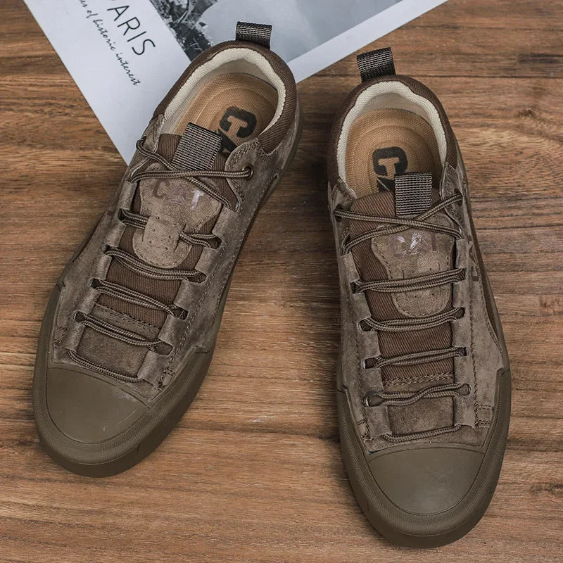 Braune Herren-Sneaker aus Wildleder auf Holzboden, modisches Design, robuste Gummisohle, ideal für Freizeit und Outdoor-Aktivitäten.