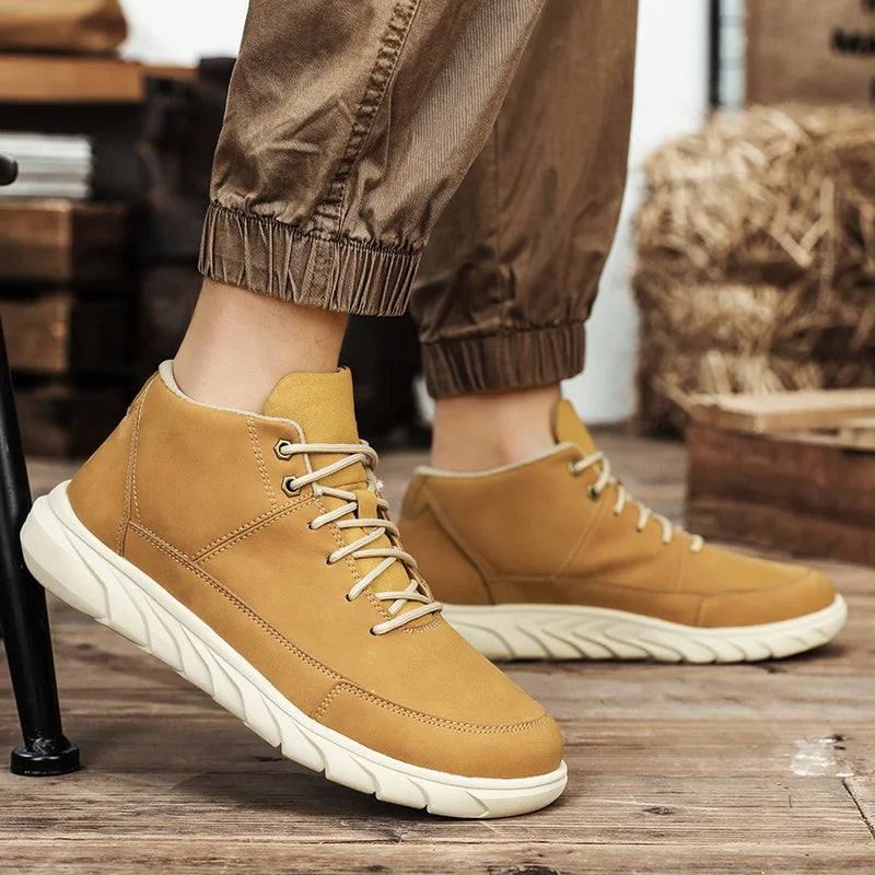 Beige Herren-Sneaker aus Leder mit weißer Sohle, getragen von Person in brauner Hose. Modische Freizeitschuhe, ideal für Herbstmode.