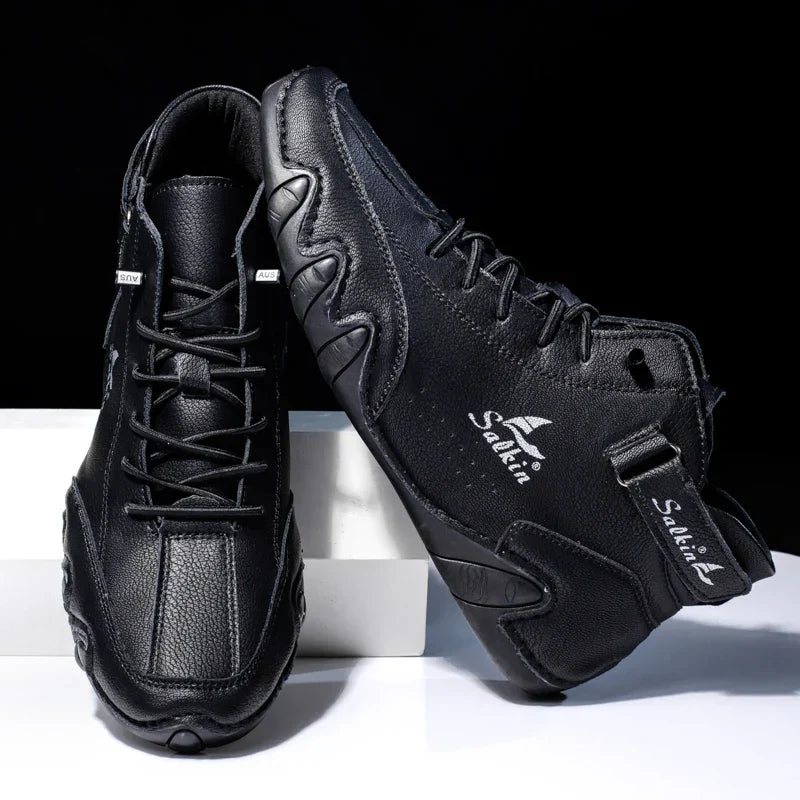 Schwarze Basketballschuhe mit hohem Schaft, Lederoptik und markantem Sohlenprofil. Ideal für Sport und Freizeit. Hochwertige Verarbeitung.