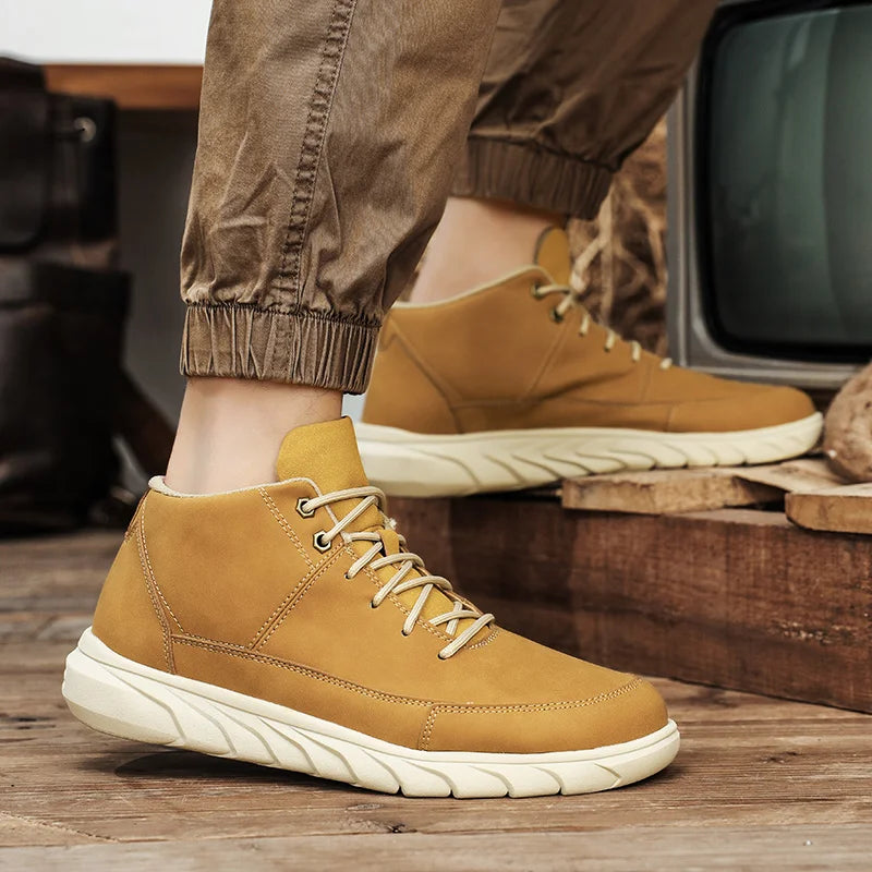 Beige Herren-Sneaker aus Leder mit weißer Sohle, getragen von Person in brauner Hose. Modische Freizeitschuhe, ideal für Herbstmode.