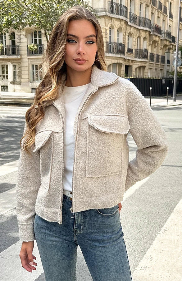 Frau in beiger Teddyjacke und blauer Jeans auf Pariser Straße, modisch, urbaner Stil, Herbstmode, lässiger Look, Stadtleben, Modefotografie.