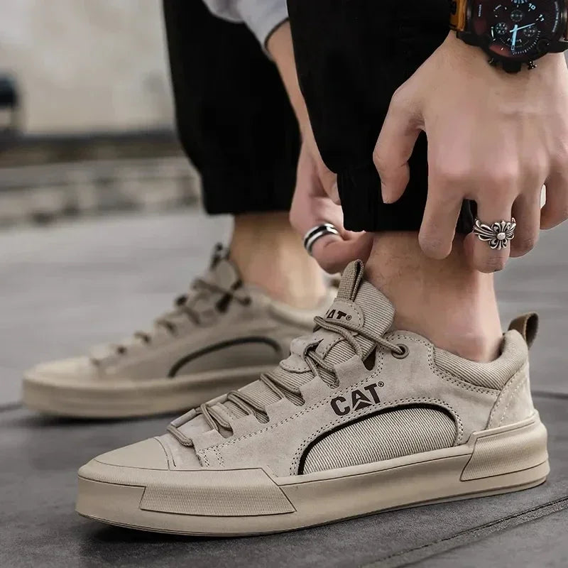Beige CAT Sneaker an Männerfuß, Nahaufnahme. Modischer Freizeitschuh, ideal für urbanen Stil. Bequeme, strapazierfähige Sneaker für Herren.