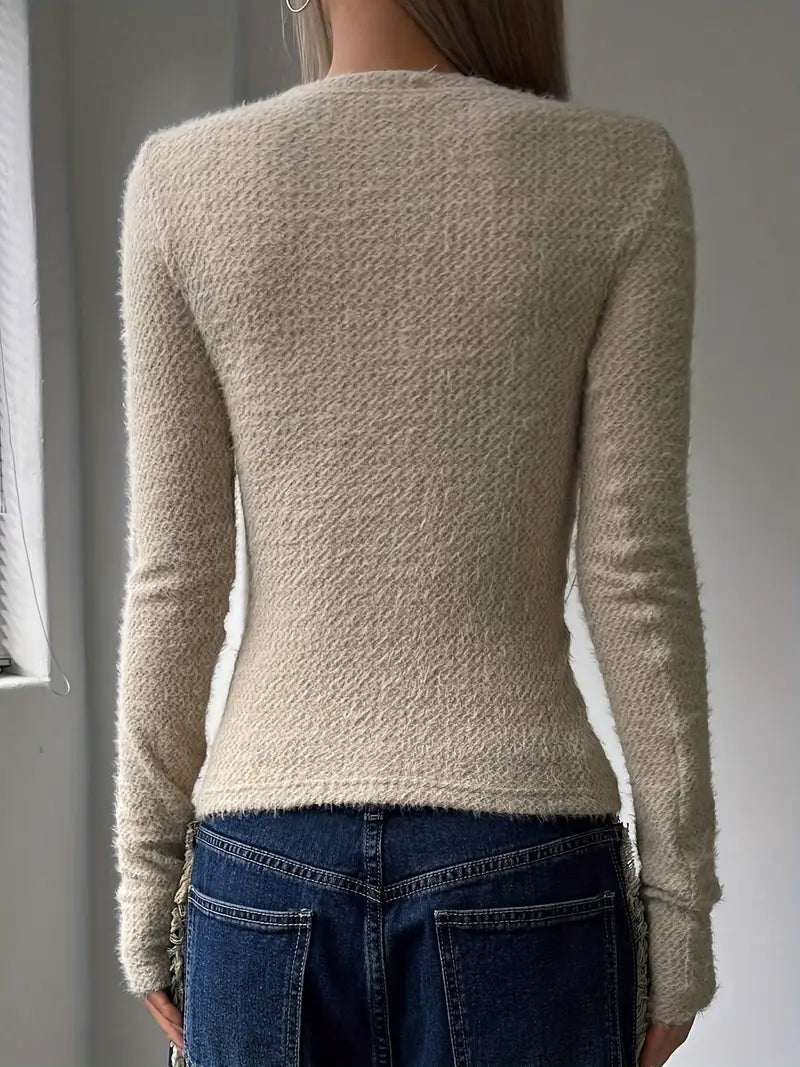 Frau in cremefarbenem Strickpullover und blauer Jeans von hinten. Modetrend, Herbstmode, Damenbekleidung, lässiger Stil.