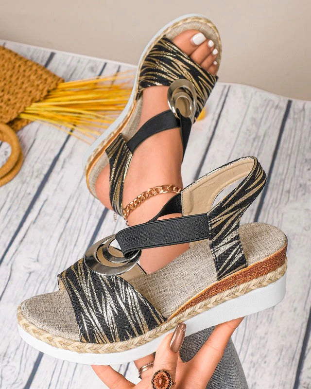 Damen-Sandalen mit Keilabsatz, schwarz-goldenes Muster, elastische Riemen, bequeme Sohle, modisches Design, ideal für Sommermode.