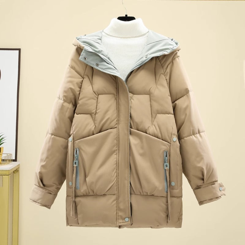 Beige Damen-Daunenjacke mit Kapuze, Reißverschlusstaschen und Steppmuster, ideal für Wintermode und Outdoor-Aktivitäten.