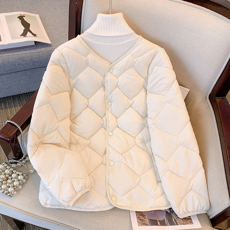 Weiße gesteppte Damenjacke auf einem Sessel, modisch und warm, ideal für den Winter. Perfekt für stilvolle Winteroutfits und kalte Tage.