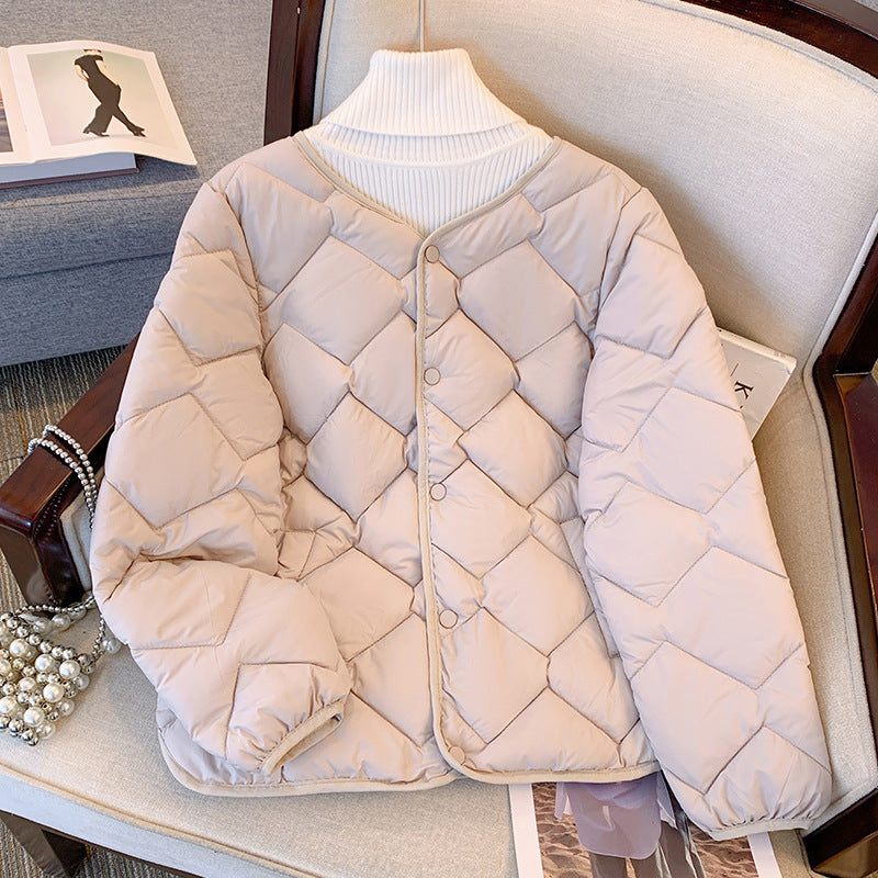 Beige gesteppte Damenjacke mit Knopfleiste auf einem Sessel, modisch und warm, ideal für Herbst und Winter. Elegantes Design, vielseitig kombinierbar.