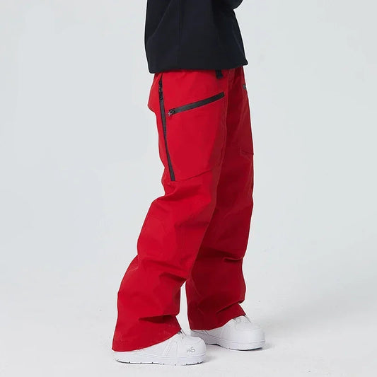 Rote Skihose mit schwarzen Reißverschlüssen, getragen von Person in schwarzem Oberteil und weißen Schuhen. Ideal für Wintersport und Outdoor-Aktivitäten.