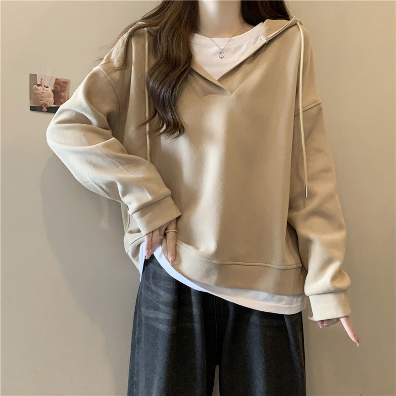 Beige Kapuzenpullover Damenmode, lässiger Stil, kombiniert mit weißem T-Shirt und dunkler Hose. Trendige Freizeitkleidung für Herbst und Winter.