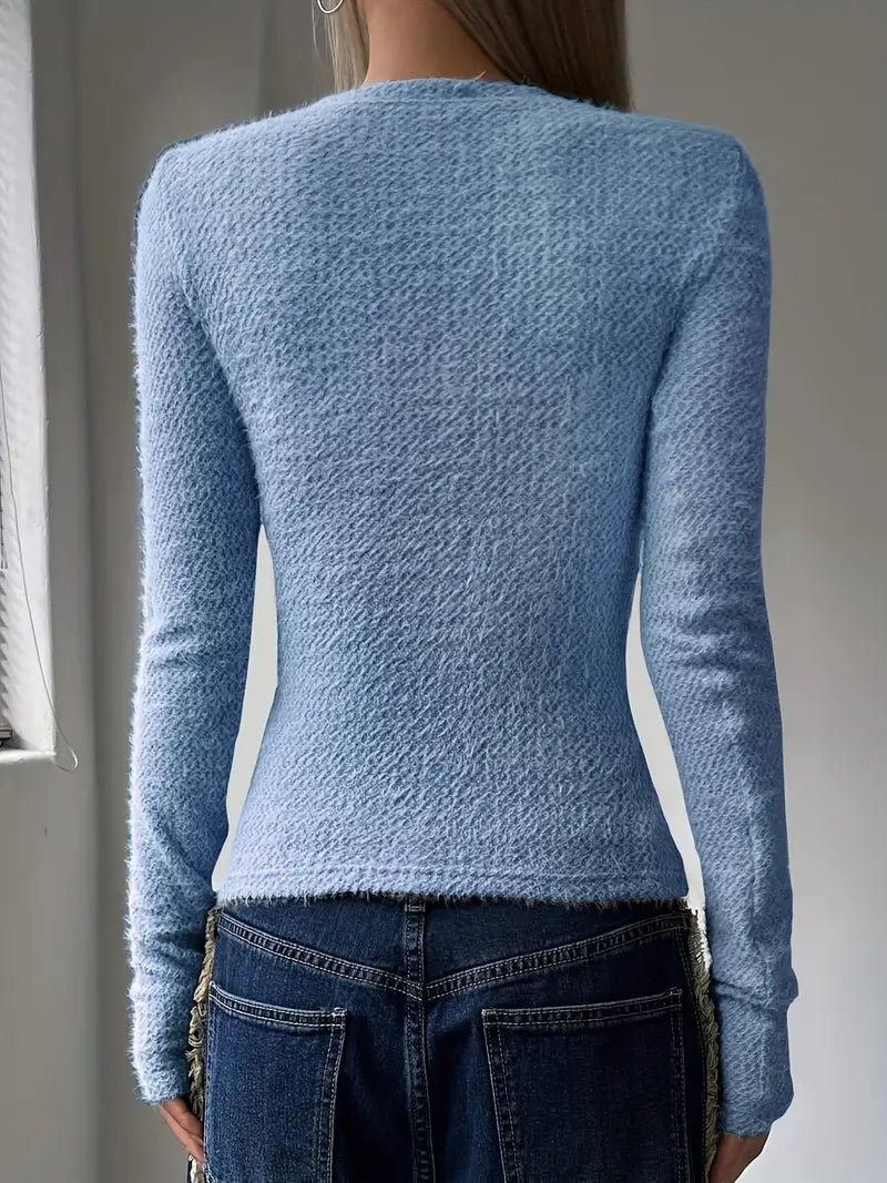 Frau in hellblauem Strickpullover und blauer Jeans von hinten. Modetrend, Damenbekleidung, Herbstmode, lässiger Stil.