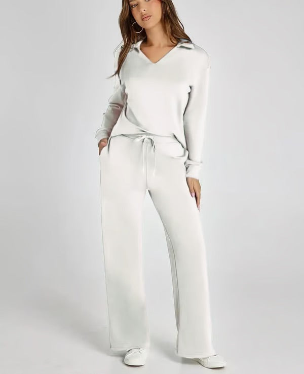 Frau in weißem Lounge-Set mit V-Ausschnitt und weiten Hosen, lässig und bequem, modisches Freizeitoutfit, ideal für Zuhause oder entspanntes Ausgehen.