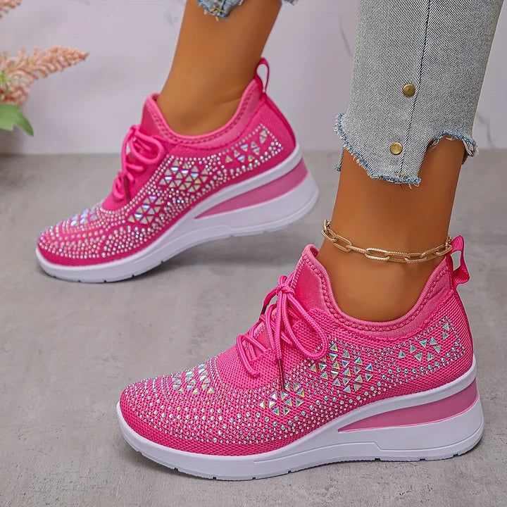 Damen pinke Sneaker mit Strass, geometrischem Muster und Keilabsatz, kombiniert mit hellblauen Jeans. Modische Sportschuhe für Frauen.
