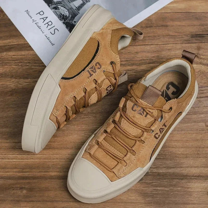 Braune CAT Sneaker auf Holzboden, modisches Design, robuste Sohle, ideal für Outdoor-Aktivitäten. Trendige Herrenschuhe, bequem und langlebig.