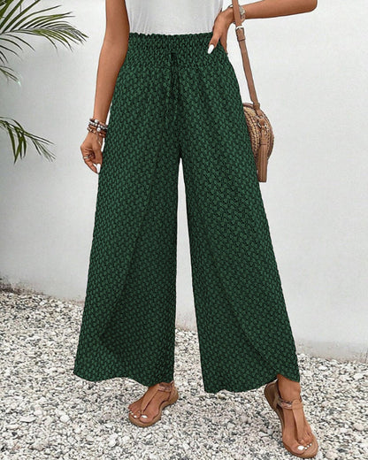 Grüne Damenhose mit weitem Bein, gemustert, kombiniert mit braunen Sandalen und einer Umhängetasche, ideal für Sommermode und Freizeitoutfits.