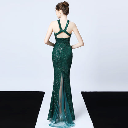 Frau in elegantem, grünem Paillettenkleid mit Rückenausschnitt und Schleppe, Abendmode, glamouröses Design, modisches Abendkleid.