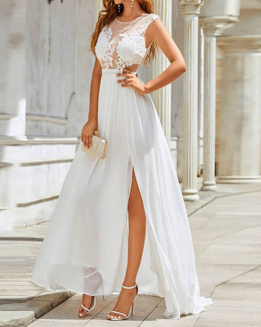 Frau in elegantem, weißem Abendkleid mit Spitzenoberteil und hohem Schlitz, hält eine goldene Clutch, steht vor Säulen. Ideal für Hochzeiten.