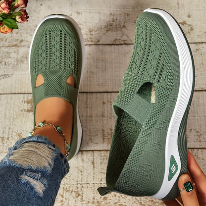 Grüne Damen-Sneaker mit Strickmuster, weiße Sohle, getragen auf Holzboden. Modische Freizeitschuhe, ideal für Frühling und Sommer.
