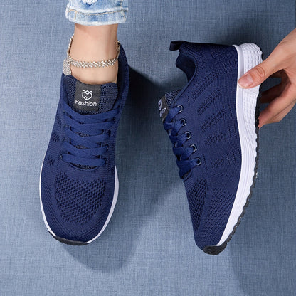 Dunkelblaue Damen-Sneaker mit weißer Sohle, modisches Design, auf Jeansstoff-Hintergrund. Bequeme Sportschuhe, ideal für Freizeit und Sport.