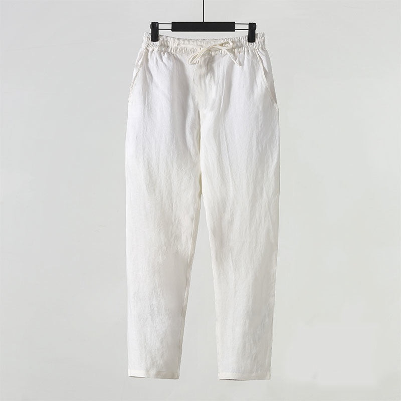 Weiße Leinenhose auf Bügel, minimalistisch, bequem, ideal für Sommermode. Hochwertige Stoffhose, lässiger Stil, elastischer Bund, zeitloses Design.