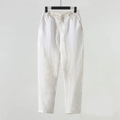 Weiße Leinenhose auf Bügel, minimalistisch, bequem, ideal für Sommermode. Hochwertige Stoffhose, lässiger Stil, elastischer Bund, zeitloses Design.
