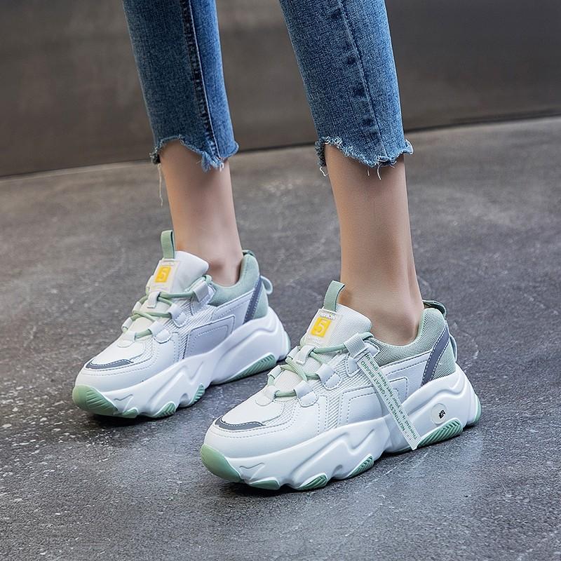 Damen-Sneaker mit dicker Sohle, weiß-grün, modisch, getragen mit hochgekrempelten Jeans. Trendige Sportschuhe für Freizeit und Streetwear.