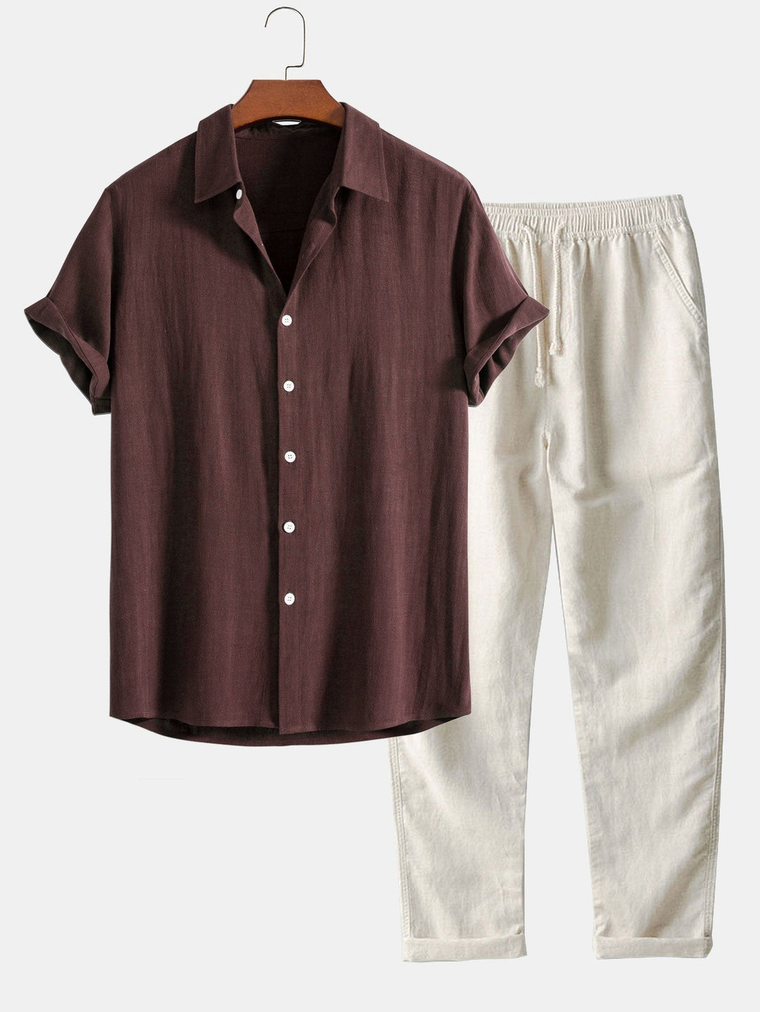 Braunes Leinenhemd mit kurzen Ärmeln und weißen Knöpfen, kombiniert mit weißen, lässigen Leinenhosen. Sommermode, Herrenbekleidung, Freizeitlook.