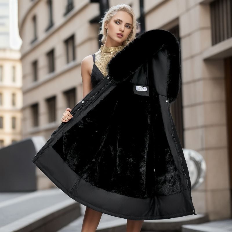 Frau in eleganter, schwarzer Winterjacke mit Kapuze und Fellfutter, steht auf städtischer Straße. Modetrend, Damenbekleidung, Wintermode.