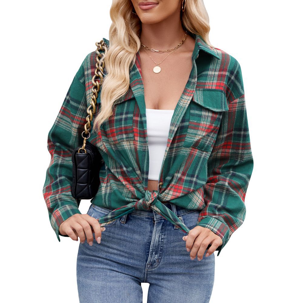 Blonde Frau in grün-kariertem Hemd, geknotet, mit weißem Top und blauer Jeans. Trägt schwarze Umhängetasche mit Kettengurt. Mode, Freizeitlook.