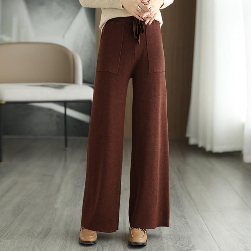 Braune Damenhose mit weitem Bein, aus weichem Stoff, kombiniert mit beigen Schuhen. Modetrend Herbst/Winter, eleganter Look für Damenmode.