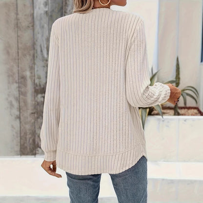 Damen Strickpullover in Creme, gerippte Struktur, lange Ärmel, lässiger Stil, kombiniert mit blauer Jeans, moderne Herbstmode.