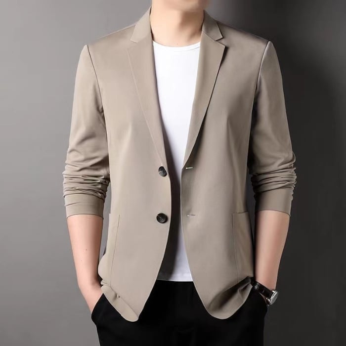 Eleganter Mann im beigen Blazer mit weißem T-Shirt und schwarzer Hose, Hände in den Taschen. Moderner Herrenmode-Look, stilvoll und zeitlos.